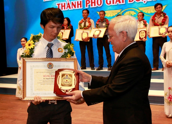 Ông Lê Hoàng Quân, Chủ tịch UBND TP, trao biểu trưng cho CNVC-LĐ điển hình