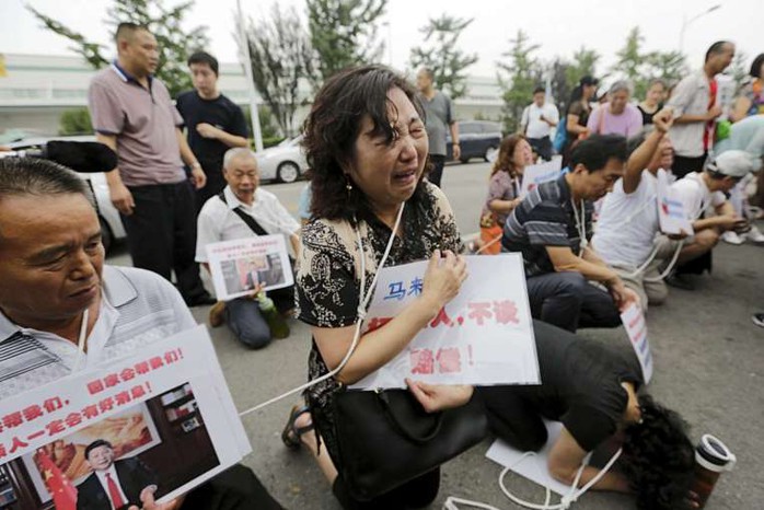 Thân nhân các hành khác Trung Quốc trên máy bay MH370 quỳ khóc ở Bắc Kinh. Ảnh: Reuters