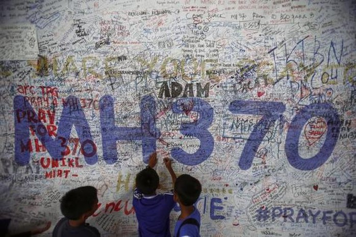 Trẻ em viết các thông điệp hy vọng cho máy bay MH370 bên ngoài sân bay quốc tế Kualum Lumpur hôm 14-6. Ảnh: Reuters