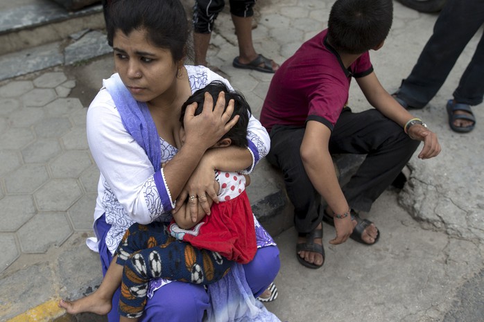 Người mẹ ôm con chạy ra đường khi động đất nổ ra ở Nepal hôm 12-5. Ảnh: Reuters