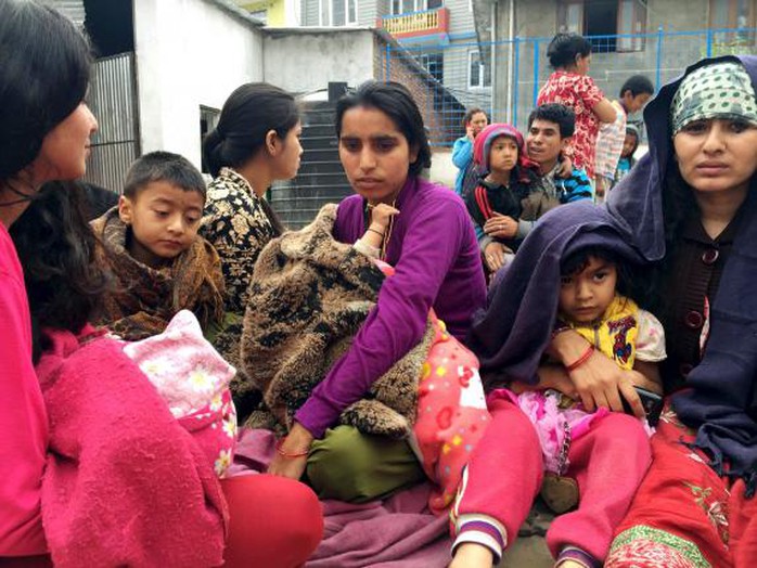 Các bà mẹ ôm con ngồi ngoài đường ở Kathmandu. Ảnh: Reuters