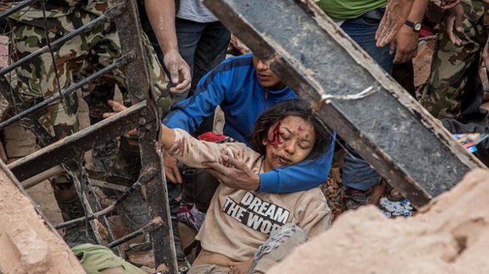 Một phụ nữ sống sót được cứu sống từ đống đổ nát ở thị trấn Dharara - Ảnh: Reuters