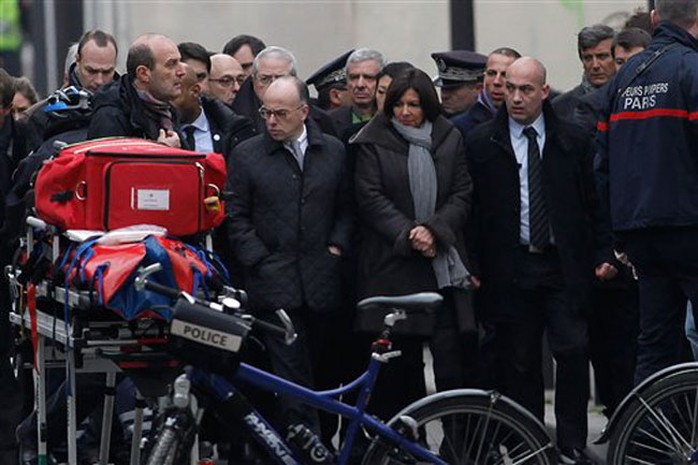 Bộ trưởng Nội vụ Pháp Bernard Cazeneuve (bìa trái) và Thị trưởng Paris, bà Anne Hidalgo tại hiện trường. Ảnh: AP