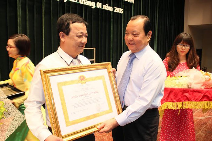 Ông Lê Thanh Hải, Ủy viên Bộ Chính trị, Bí thư Thành ủy TP HCM, trao Huân chương lao động hạng 3 cho ông Trần Đức Phương, Hiệu trưởng Trường Trung cấp Công đoàn TP 
Ảnh: HOÀNG TRIỀU