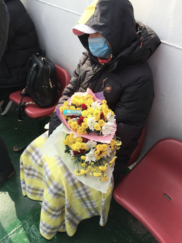 Một số người mang theo hoa để tưởng nhớ người thân thiệt mạng trong vụ chìm phà. Ảnh: CNA