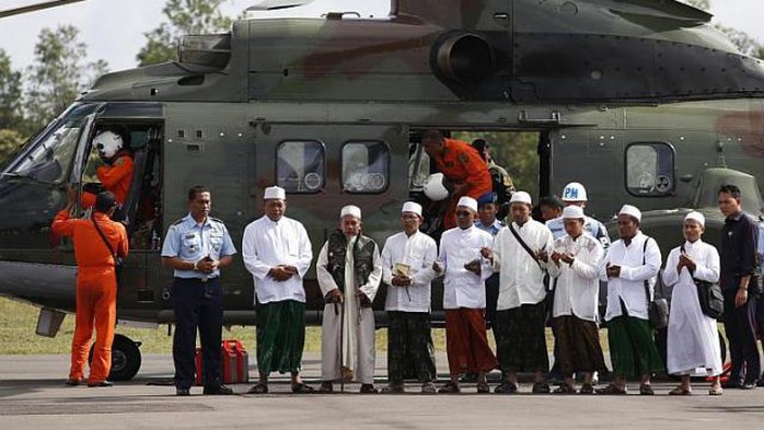 Các giáo sĩ được trực thăng đưa đến khu vực rơi máy bay cầu nguyện cho các nạn nhân. Ảnh: Reuters