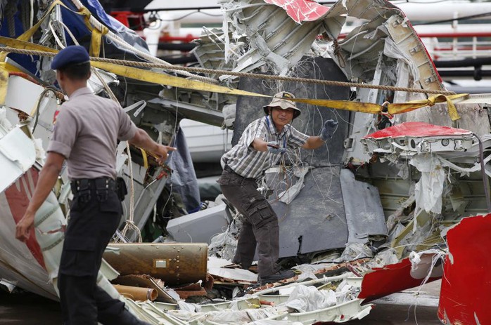Các nhân viên từ Ủy ban An toàn Giao thông Quốc gia Indonesia đang kiểm tra phần đuôi máy bay hôm 12-1. Ảnh: Reuters