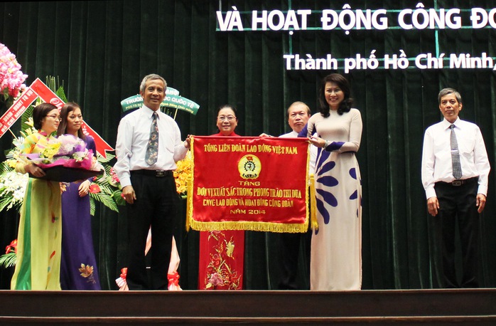 Ông Đặng Ngọc Tùng, Chủ tịch Tổng LĐLĐ Việt Nam, trao cờ thi đua xuất sắc của Tổng LĐLĐ Việt Nam cho tập thể thường trực LĐLĐ TP  Ảnh: HOÀNG TRIỀU