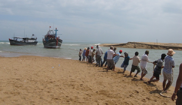Ngư dân tham gia cứu hộ 2 tàu cá bị mắc cạn tại cửa biển Đà Diễn - Ảnh: A.NGỌC