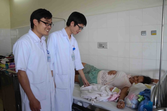 Bác sĩ Lưu Hồng Tuyên (trái) và bác sĩ Lê Khắc Hiệu thăm sản phụ Zơ Rum Chăm sau ca sinh mổ thành công