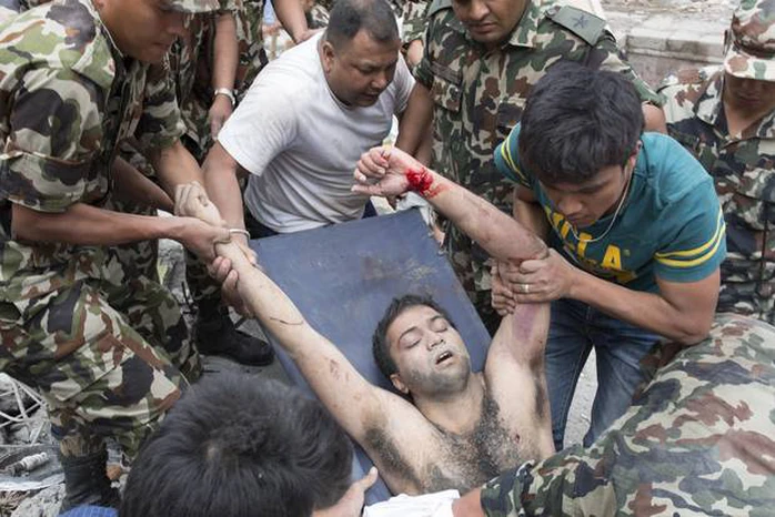 Một người đàn ông được kéo ra khỏi đống đổ nát ở TP Kathmandu. Ảnh: New York Times
