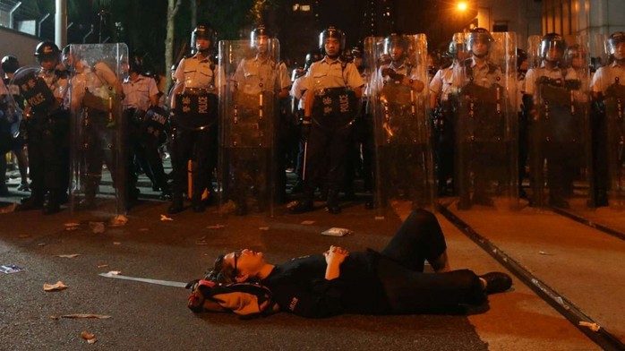 Một người biểu tình nằm ăn vạ trước hàng rào cảnh sát. Ảnh: SCMP