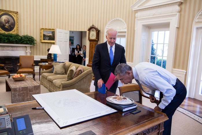 Tổng thống Obama thổi nến trên bánh sinh nhật do ông Biden mang tới Phòng Bầu dục ngày 4-8-2016. Ảnh: NHÀ TRẮNG