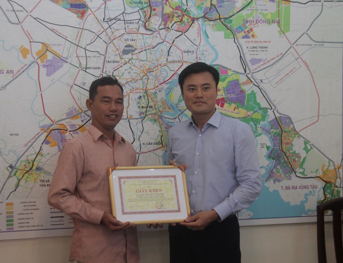 
Ông Nguyễn Văn Linh (bìa trái) được Giám đốc Sở GTVT Bùi Xuân Cường trao bằng khen sáng 25-11
