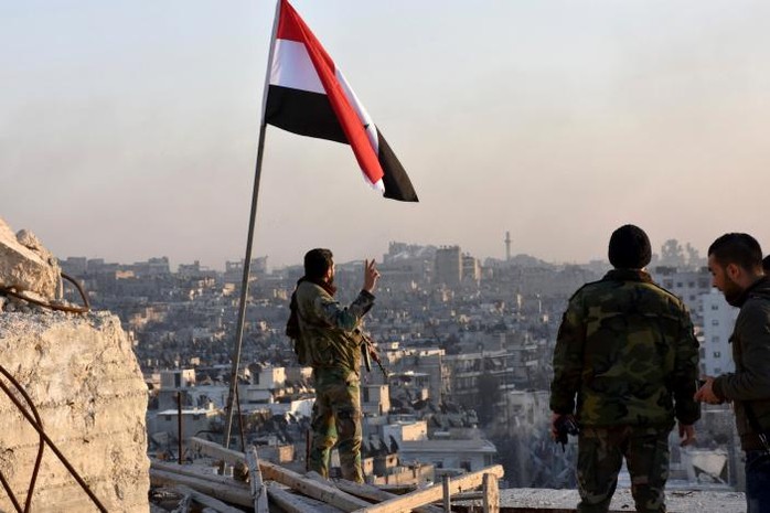 
Quân đội Syria cắm cờ tại khu phố al-Sakhour, Aleppo vừa được giải phóng. Ảnh: SANA
