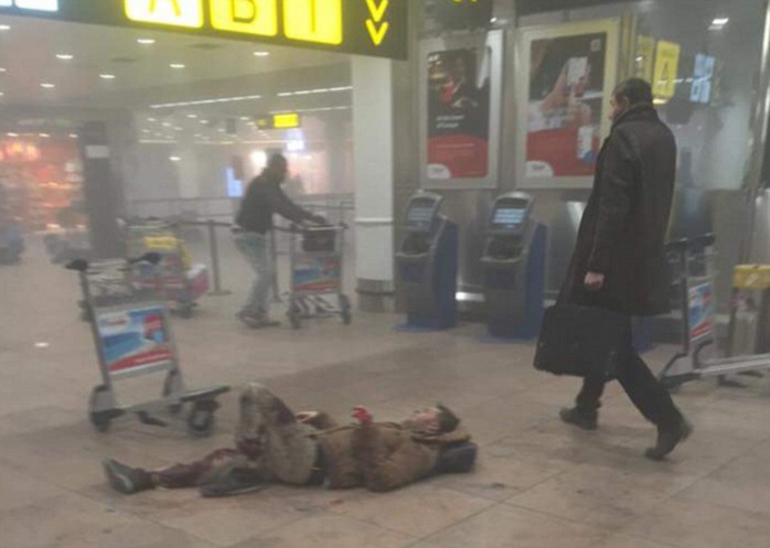 A man lies injured on the floor after two explosions rocked the the American Airlines check-in desk