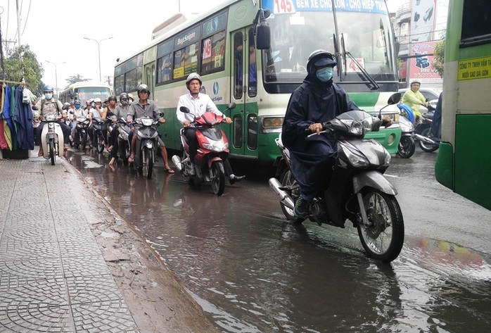 
Nhiều người đi xe máy tránh vũng nước đọng trên mặt đường càng gây cảnh lộn xộn và kẹt xe

