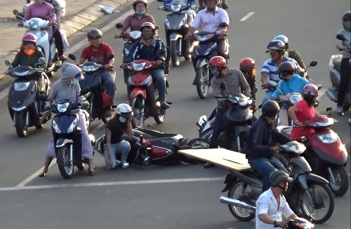 Do xe cộ lưu thông đông đúc, loạn xạ dẫn đến xảy ra va chạm khiến cô gái cùng xe máy ngã lăn ra đường Phạm Văn Đông đoạn gần giao lộ đường 25 - Phạm Văn Đồng.