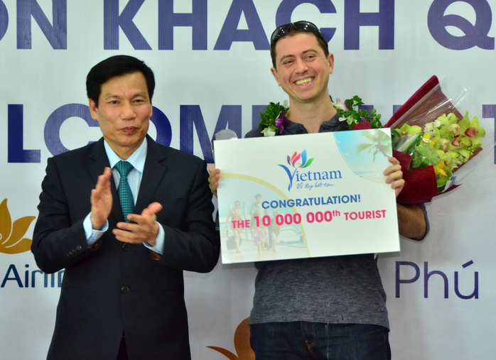 
Ông Nguyễn Ngọc Thiện, Bộ trưởng Bộ Văn hóa - Thể thao và Du lịch (trái), tặng hoa và kỷ niệm chương cho du khách thứ 10 triệu đến Việt Nam trong năm 2016
