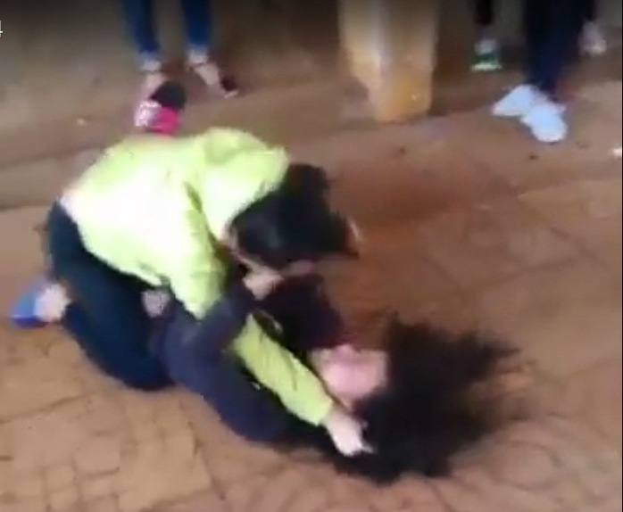 
Nữ sinh đánh nhau trong tiếng reo hò của bạn bè. Ảnh cắt từ clip
