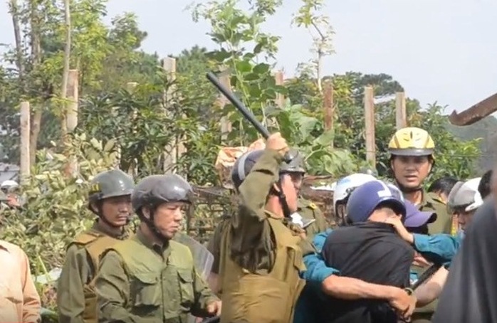 
Lực lượng công an xã vây giật máy ảnh của phóng viên Đỗ Thanh Hải (áo khoác đen)
