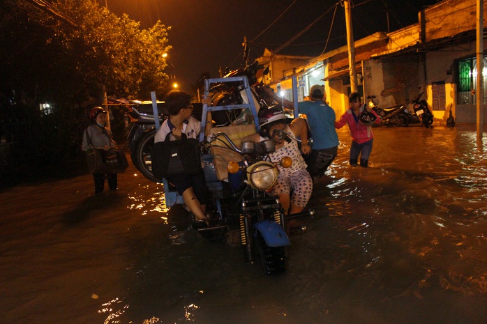 Những xe ba gác xuất hiện tại các đoạn đường ngập để giải cứu các phương tiện chết máy qua các đoạn nước ngập với giá khoảng 50.000 - 100.000 đồng.