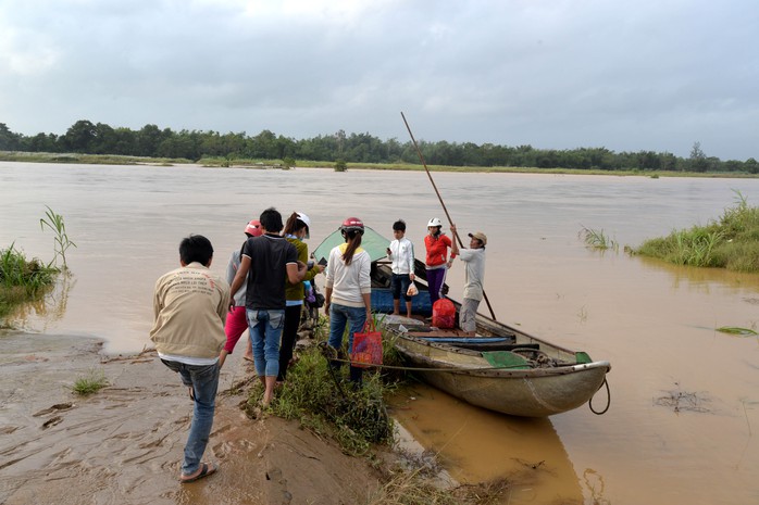 Người dân thôn An Phú, xã Tịnh An, TP Quảng Ngãi dùng ghe vượt qua dòng nước lũ để về nhà. Ảnh: Tử Trực