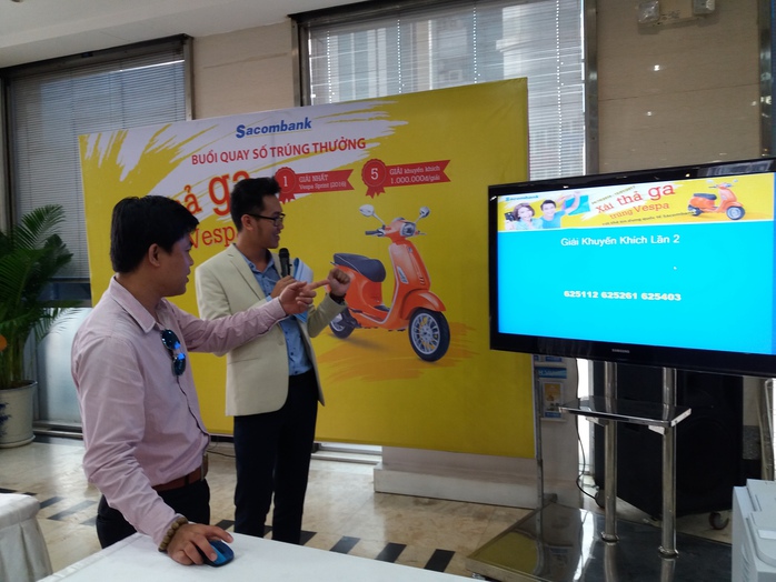 Chủ thẻ tín dụng quốc tế Sacombank (bên trái) tham gia quay số trúng thưởng
