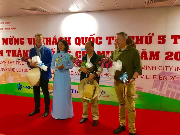 
Bà Nguyễn Thị Thu, Phó Chủ tịch UBND TP HCM, tặng hoa và quà cho ông Chappe Bertrand (thứ hai từ phải sang) và 2 vị khách may mắn
