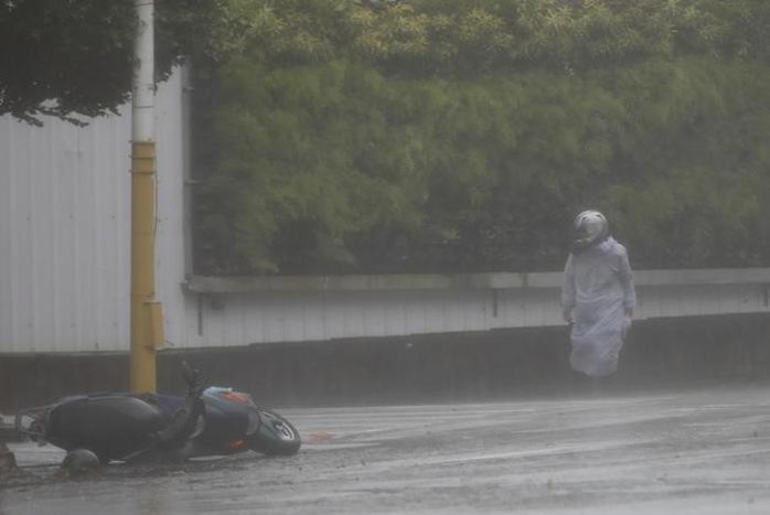 
Người đi xe máy tại huyện Hoa Liên - Đài Loan khốn khổ vì bão hôm 27-9. Ảnh: REUTERS
