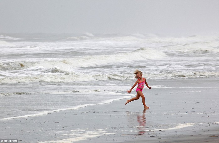 
Một em bé chơi đùa trên bãi biển ở bang South Carolina ngày 7-10 bất chấp cảnh báo bão. Ảnh: REUTERS
