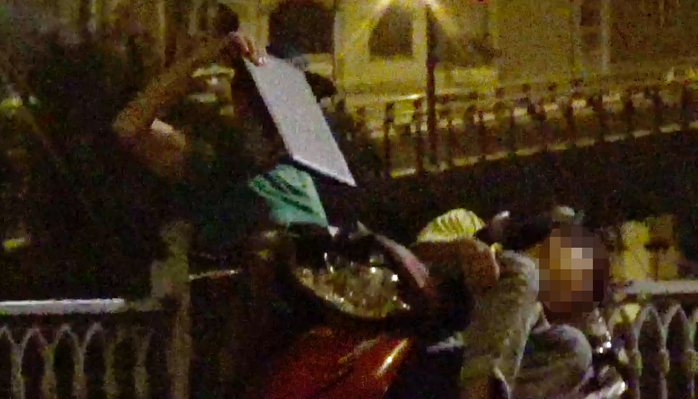 
Một thành viên băng hai ngón đang lấy laptop của một thanh niên tại chân cầu Mống.
