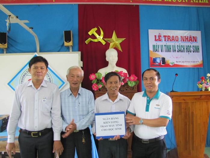 Đại diện Ngân hàng Kiên Long tại Đà Nẵng (bìa phải) trao quà là 5 bộ máy tính cho Trường Tiểu học số 2 Duy Sơn (huyện Duy Xuyên, tỉnh Quảng Nam) Ảnh: HOÀNG DŨNG