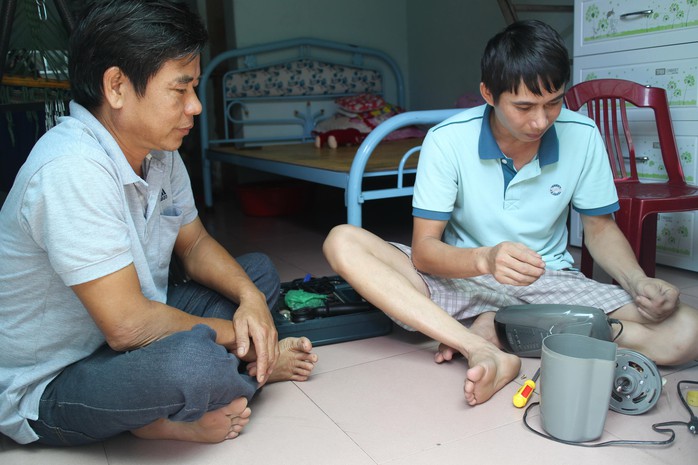 Anh Nguyễn Thành Tâm (trái) thăm hỏi công nhân ở trọ