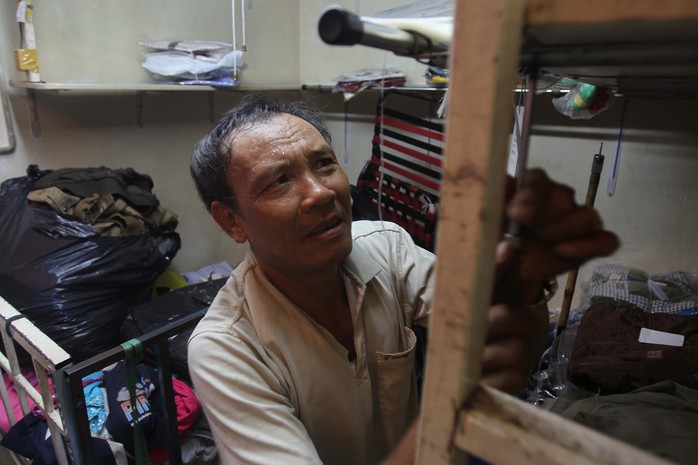
Ông Tuấn (chủ của một cửa hàng quần áo) tháo các kệ trong sạp để mang về nhà
