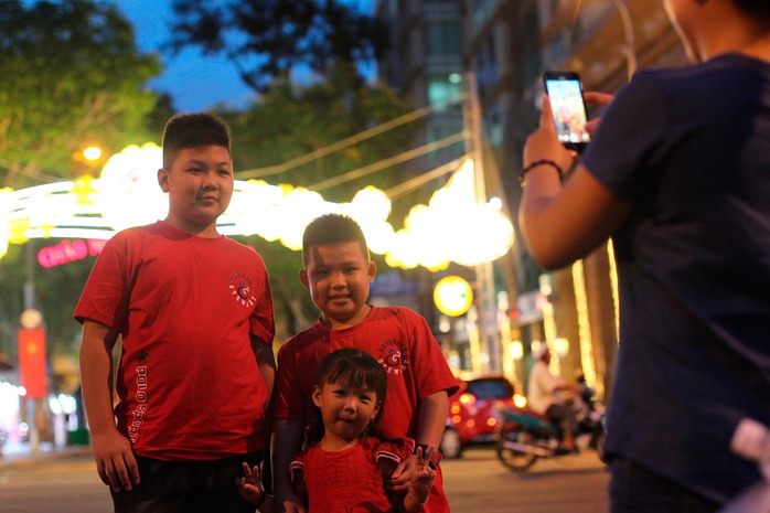 
Một gia đình chụp ảnh trước cồng chào phía đường Đồng Khởi
