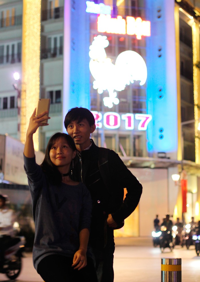 
Hai bạn trẻ selfie trước hình ảnh đèn led hình biểu tượng năm Đinh Dậu trên phố đi bộ Nguyễn Huệ
