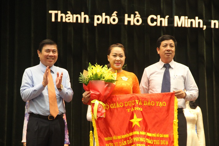 Chủ tịch UBND TP HCM Nguyễn Thành Phong (bìa trái) trao cờ thi đua cho các trường tiêu biểu Ảnh: Đặng Trinh