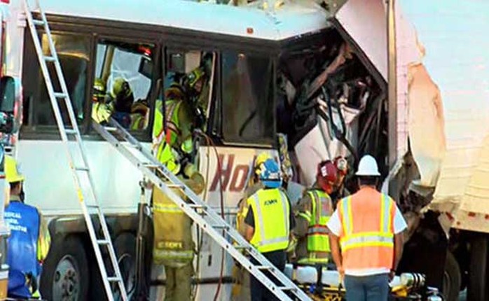 
Các nhân viên cứu hộ phải dùng thang leo vào cửa sổ xe buýt để đưa thi thể nạn nhân ra ngoài. Ảnh: Reuters
