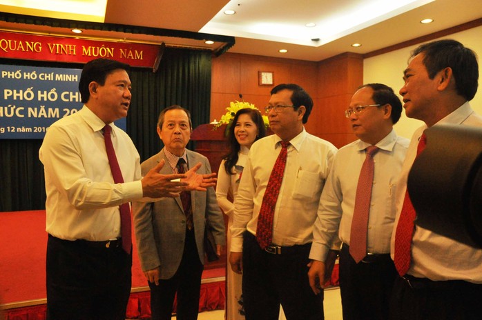 Bí thư Thành ủy TP HCM Đinh La Thăng (bìa trái) và Phó Bí thư Thường trực Thành ủy Tất Thành Cang (thứ 2, từ phải sang) gặp gỡ các trí thức vào ngày 20-12