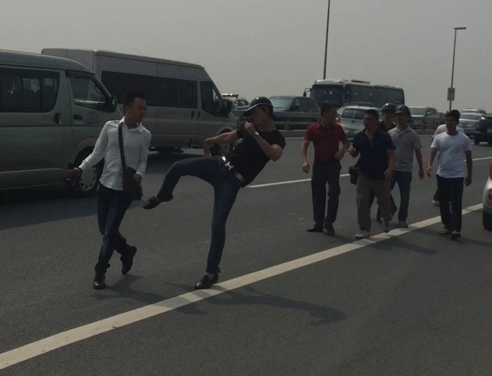 Nhà báo Quang Thế (áo trắng) bị nhóm thanh niên hành hung khi tác nghiệp trên cầu Nhật Tân sáng 23-9Ảnh: Minh Chiến