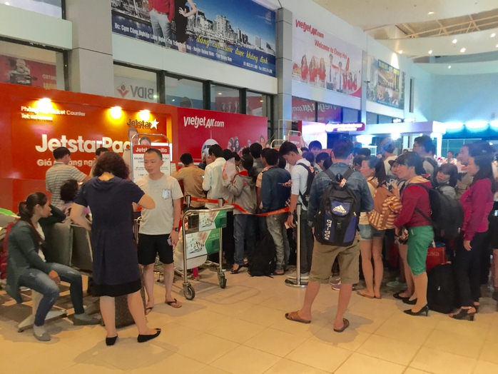 Hành khách tranh thủ làm thủ tục tại sân bay Đồng Hới do một chuyến bay bị hoãn hôm 26-9. Ảnh: DUY CƯỜNG