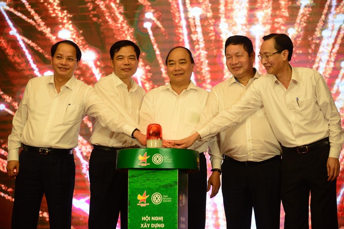 Thủ tướng Nguyễn Xuân Phúc ấn nút khởi động chương trình truy xuất nguồn gốc rau an toàn. Ảnh: HOÀNG TRIỀU