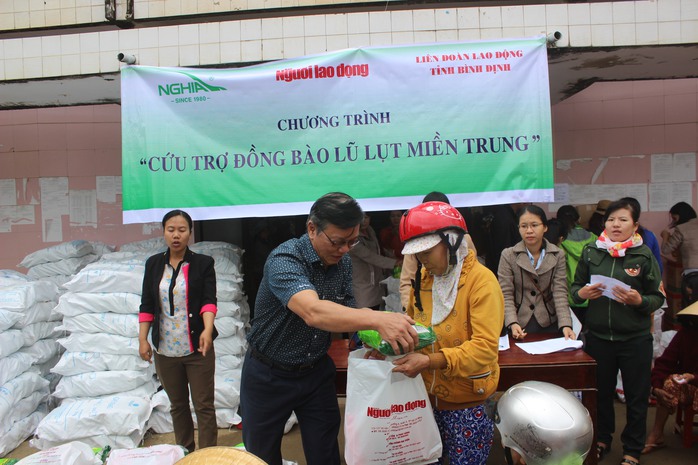 
Ông Nguyễn Văn Tín, Phó Tổng Biên tập Báo Người Lao Động, trao quà cho người dân vùng lũ Tuy Phước
