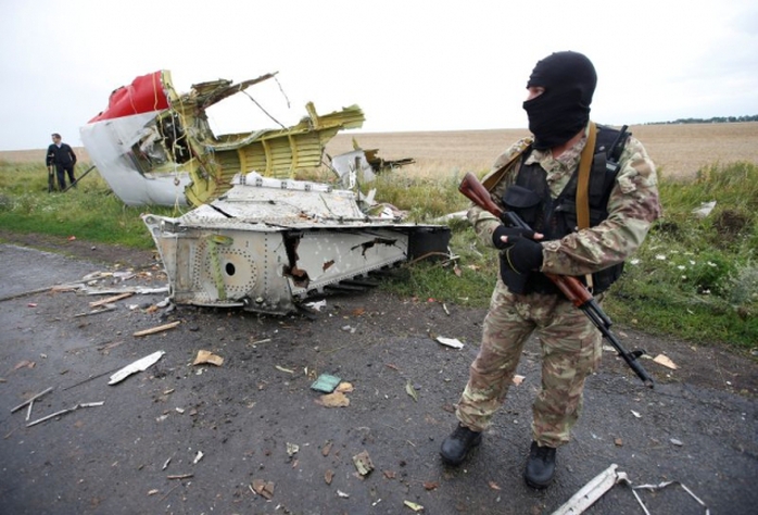 
Một phiến quân thân Nga đứng tại hiện trường vụ rơi MH17 ở làng Hrabove, miền Đông Ukraine năm 2014. Ảnh: Reuters

