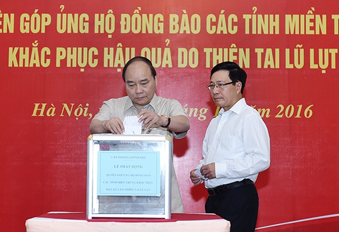 Thủ tướng Nguyễn Xuân Phúc và Phó Thủ tướng Phạm Bình Minh quyên góp ủng hộ đồng bào miền Trung bị thiệt hại do lũ lụt - Ảnh: Quang Hiếu