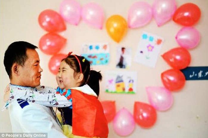 
Cô bé Shi Haiqing ôm cổ bố cười tươi trong đám cưới. Ảnh: Peoples Daily Online
