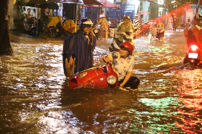 Một người dân té ngã khi lưu thông trong tình trạng mưa ngập - Ảnh: LÊ PHONG