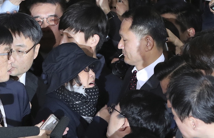 Bà Choi Soon-sil giữa báo giới, an ninh và người biểu tình ngày 31-10 Ảnh: AP