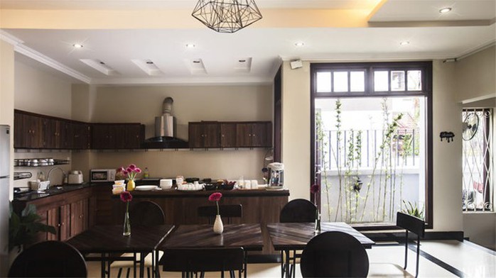 Hostel có phòng bếp rộng rãi, nội thất gỗ tông nâu trầm tạo vẻ sang trọng, lịch sự, có đầy đủ tiện nghi cho du khách nếu muốn tự tay vào bếp. Ánh sáng nắng tự nhiên khiến căn bếp trông gần gũi khiến đồ ăn cũng đẹp mắt và ngon hơn. Ảnh: 1812 Boutique Hostel.